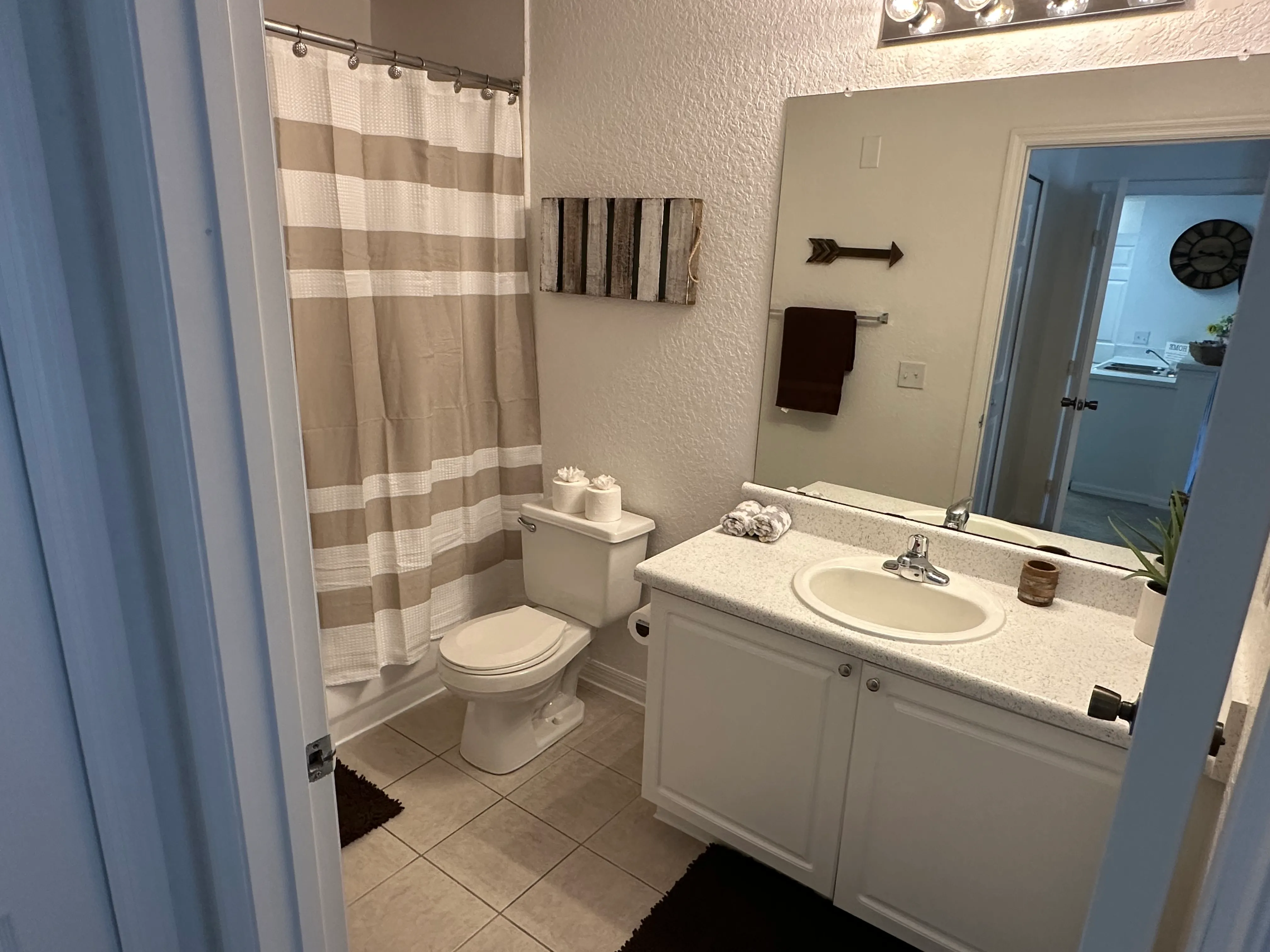 A bathroom with a toilet, sink, and shower curtain.