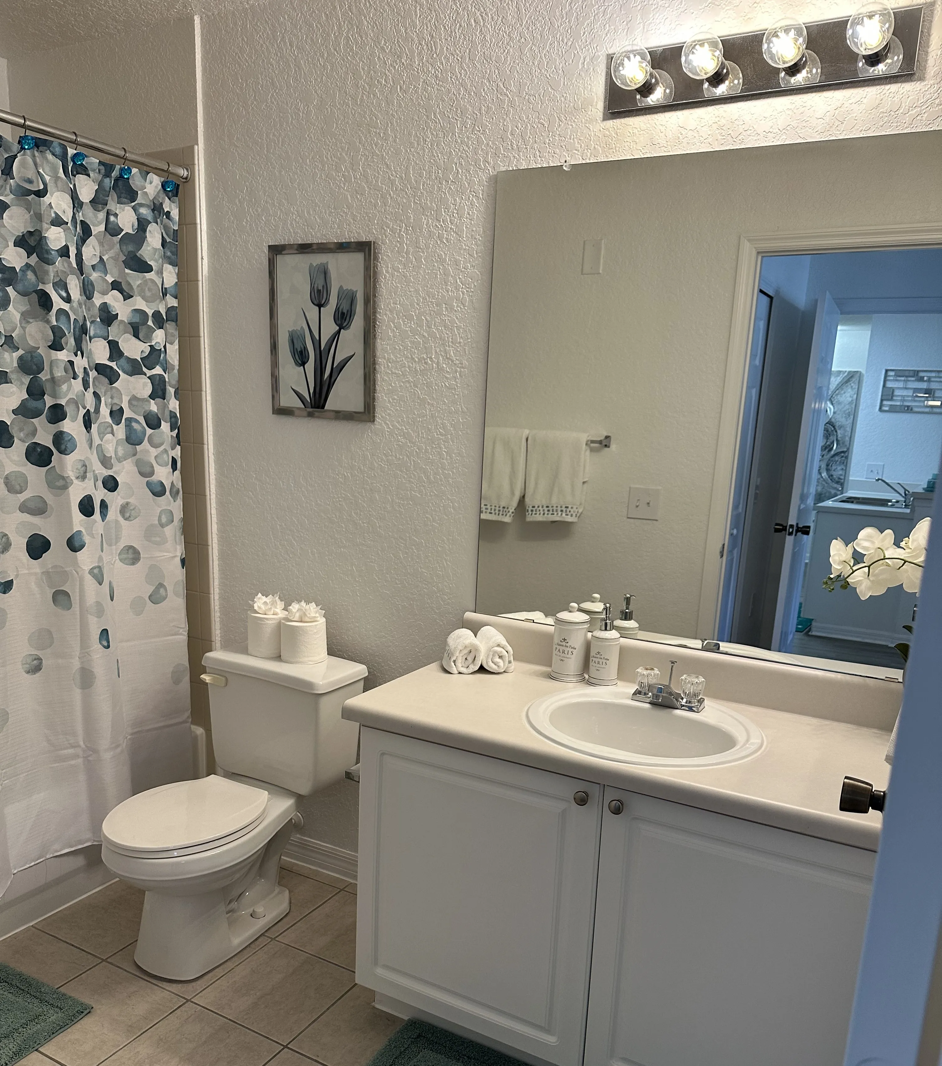 A white bathroom with a toilet, sink, and mirror.