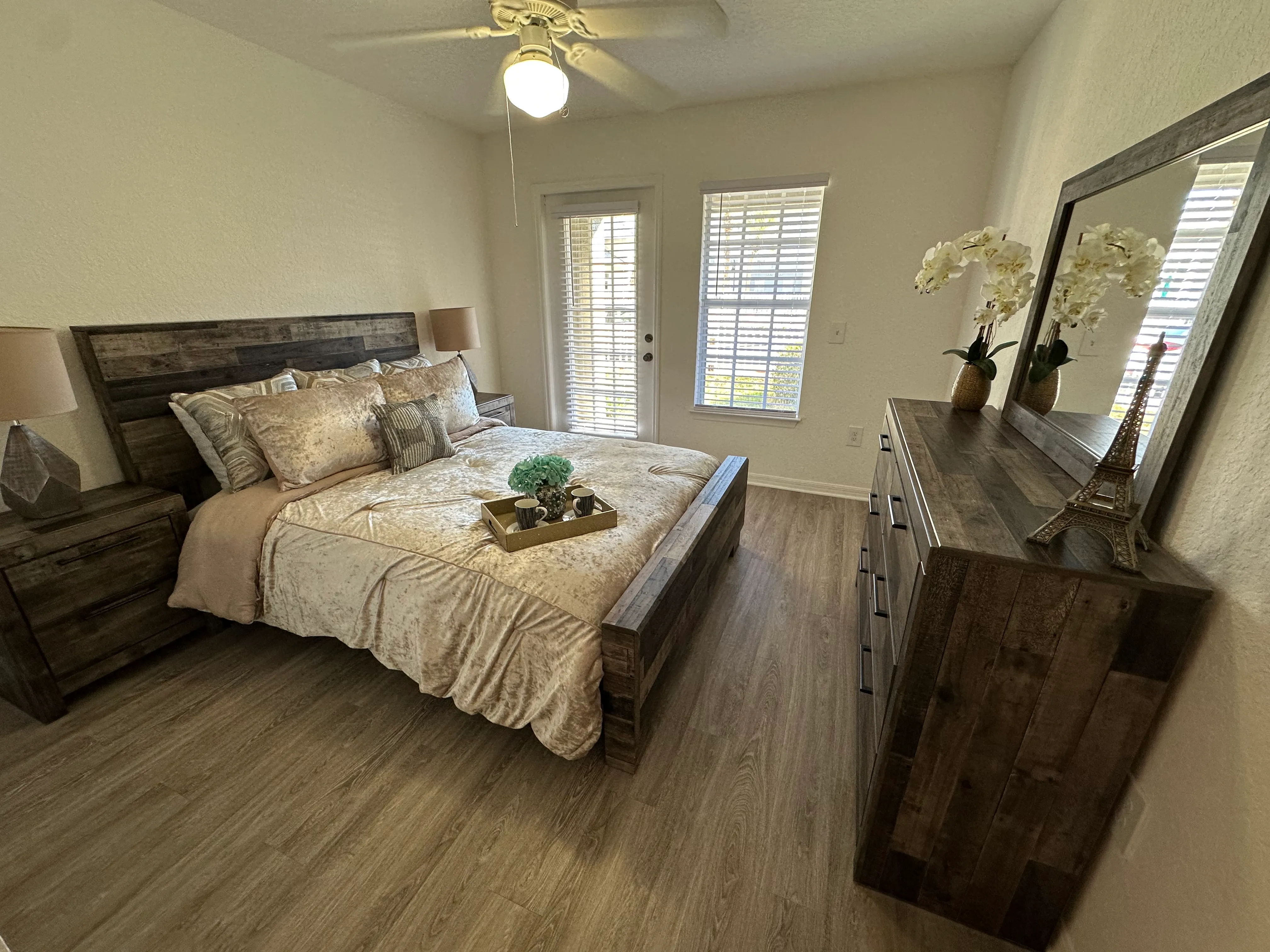 A bedroom with a bed, dresser, and mirror.