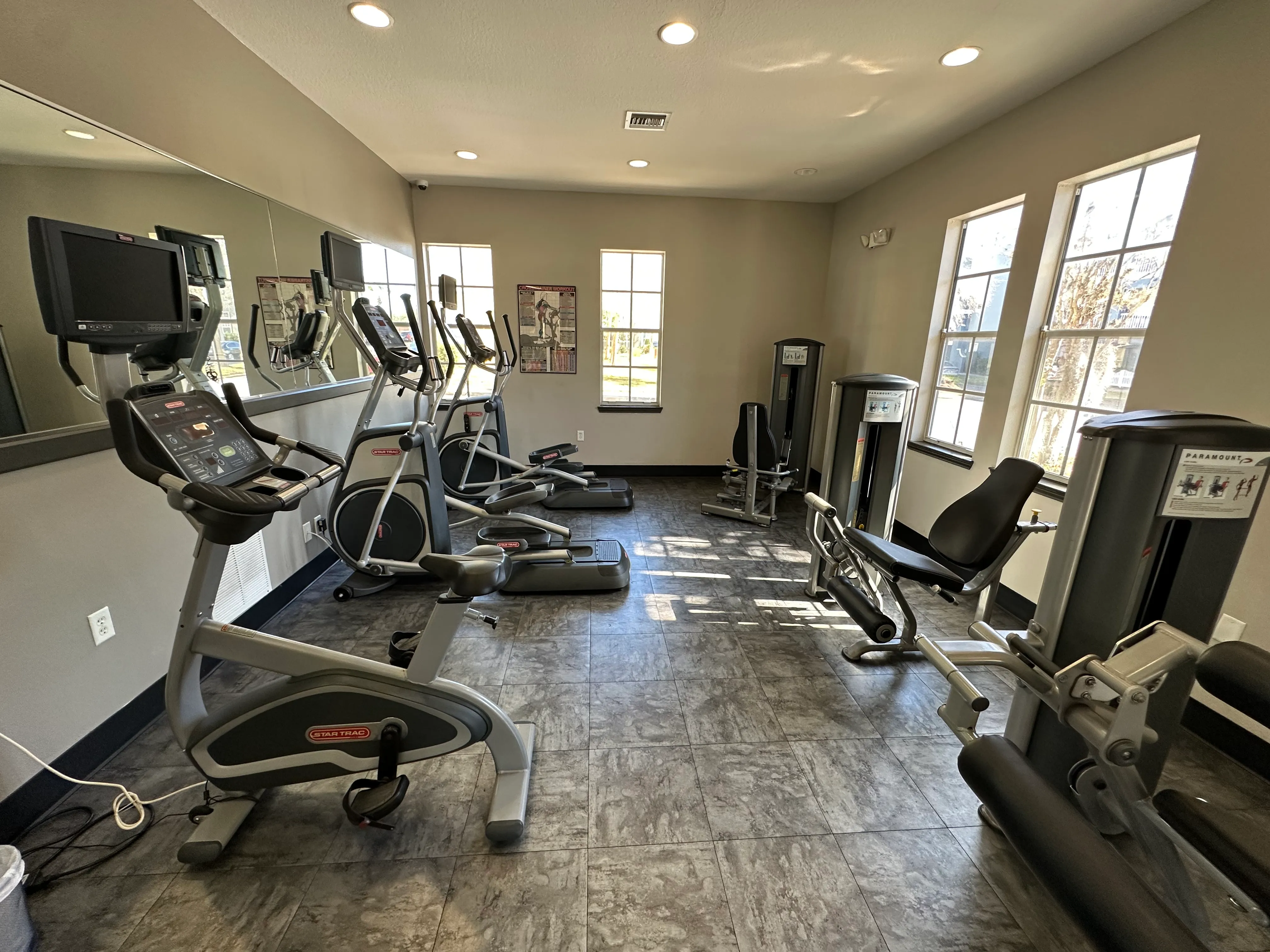 A gym with treadmills, elliptical machines, and other exercise equipment.